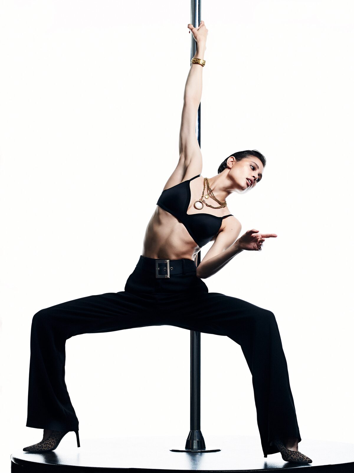 Model in black leaning from a pole, photographed by Alexey Kolpakov
